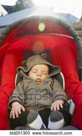 Stock Image - Caucasian baby sleeping in car seat. Fotosearch