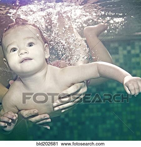 Stock Image - Caucasian baby swimming under water. Fotosearch