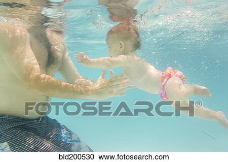 Stock Image - Caucasian baby swimming underwater. Fotosearch