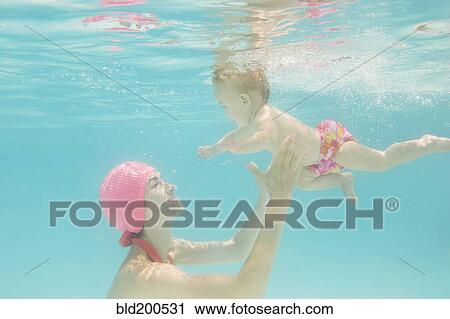 Stock Image - Caucasian baby swimming underwater. Fotosearch