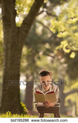 Caucasian boy reading book in yard View Large Photo Image Stock Photograph - Caucasian boy reading book in yard. Fotosearch