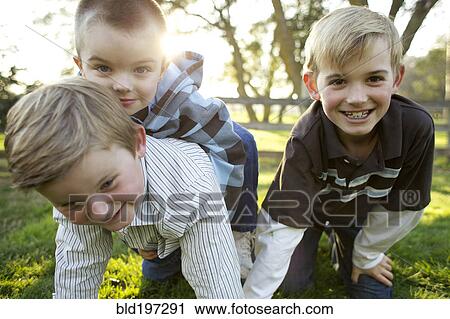 Stock Image - Caucasian brothers playing in grass. Fotosearch