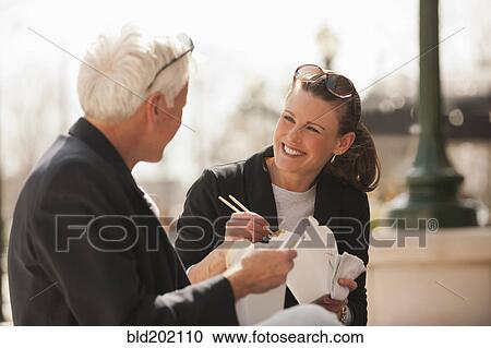 Stock Image - Caucasian business people eating Asian food. Fotosearch