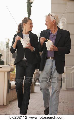 Stock Image - Caucasian business people eating Asian food. Fotosearch