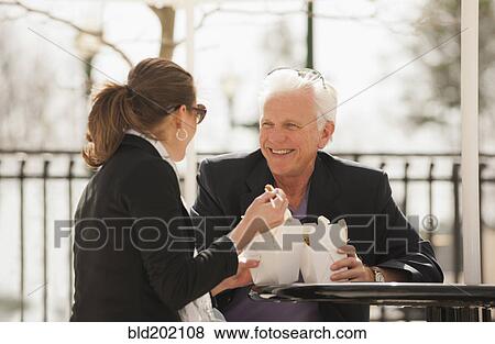 Stock Photo - Caucasian business people eating Asian food. Fotosearch