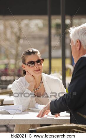 Stock Image - Caucasian business people talking in cafe. Fotosearch