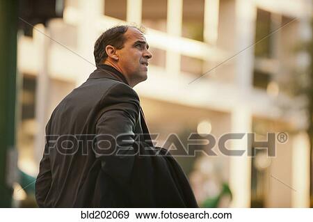 Caucasian businessman carrying coat View Large Photo Image Stock Photo - Caucasian businessman carrying coat. Fotosearch