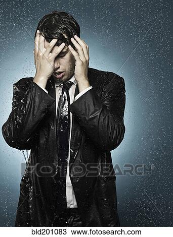 Stock Image - Caucasian businessman caught in the rain. Fotosearch