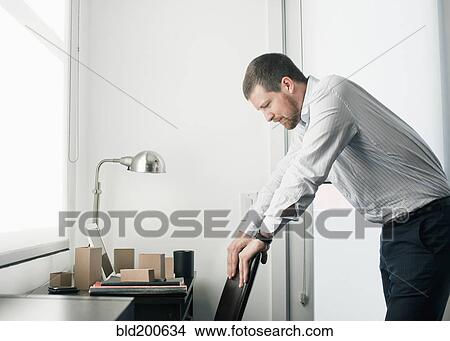 Picture - Caucasian businessman leaning on chair. Fotosearch