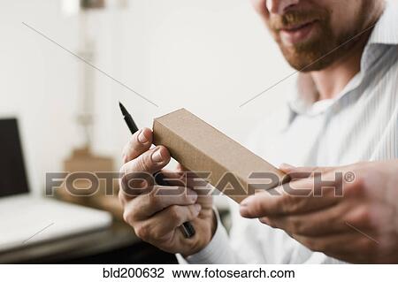 Stock Image - Caucasian businessman looking at prototype. Fotosearch