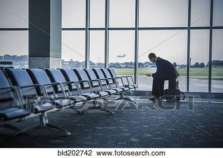 Caucasian businessman sitting suitcase in airport View Large Photo Image Stock Image - Caucasian businessman sitting suitcase in airport. Fotosearch