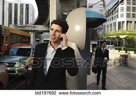 Caucasian businessman talking on cell phone outdoors View Large Photo Image Stock Image - Caucasian businessman talking on cell phone outdoors. Fotosearch