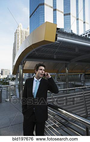 Caucasian businessman talking on cell phone outdoors View Large Photo Image Stock Photograph - Caucasian businessman talking on cell phone outdoors. Fotosearch