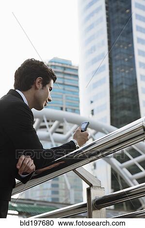 Caucasian businessman text messaging on cell phone outdoors View Large Photo Image Stock Image - Caucasian businessman text messaging on cell phone outdoors. Fotosearch