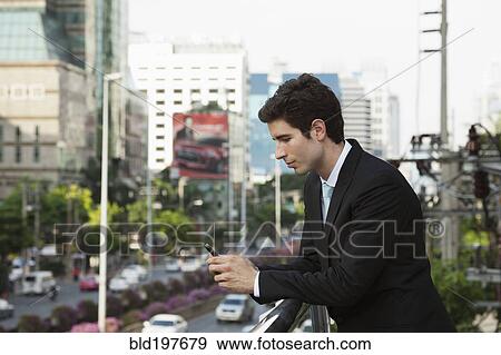 Caucasian businessman text messaging on cell phone outdoors View Large Photo Image Stock Photo - Caucasian businessman text messaging on cell phone outdoors. Fotosearch