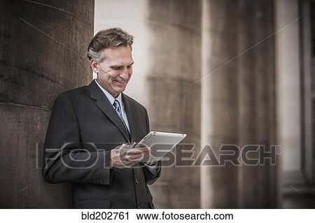 Caucasian businessman using tablet computer View Large Photo Image Stock Image - Caucasian businessman using tablet computer. Fotosearch