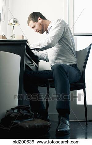Stock Photograph - Caucasian businessman working at desk. Fotosearch