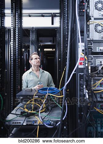Stock Photograph - Caucasian businessman working in server room. Fotosearch