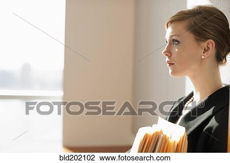 Stock Image - Caucasian businesswoman holding files. Fotosearch