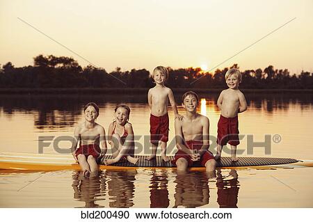 Caucasian children sitting on paddleboard View Large Photo Image Stock Image - Caucasian children sitting on paddleboard. Fotosearch