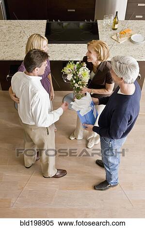 Caucasian couple giving hosts gift and flowers View Large Photo Image Stock Photography - Caucasian couple giving hosts gift and flowers. Fotosearch
