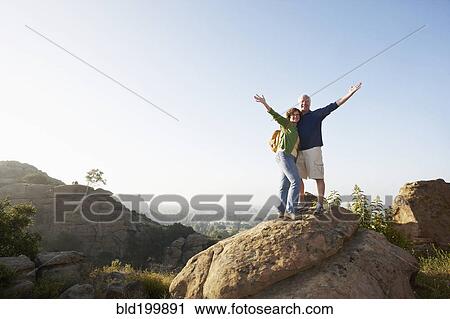 Stock Image - Caucasian couple hiking in remote area. Fotosearch