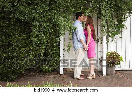 Picture - Caucasian couple holding hands and kissing. Fotosearch