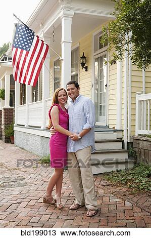 Stock Image - Caucasian couple hugging near porch. Fotosearch
