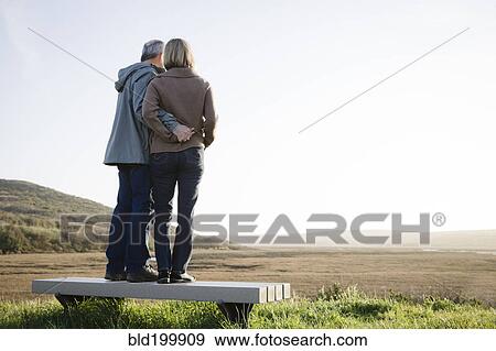 Stock Photo - Caucasian couple hugging on beach. Fotosearch