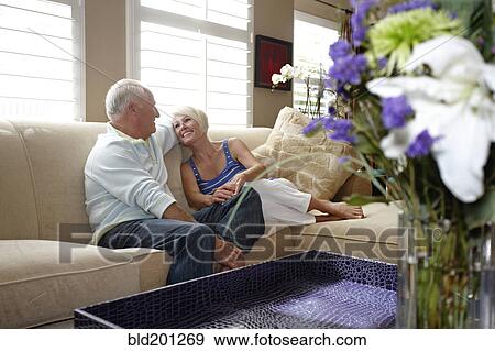 Caucasian couple sitting on sofa View Large Photo Image Stock Photo - Caucasian couple sitting on sofa. Fotosearch