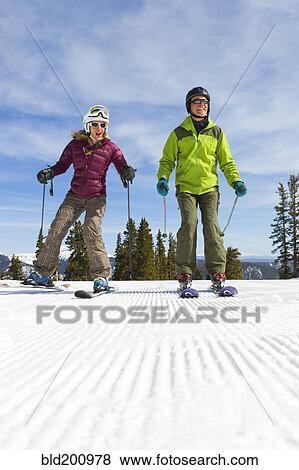 Stock Photo - Caucasian couple skiing together. Fotosearch