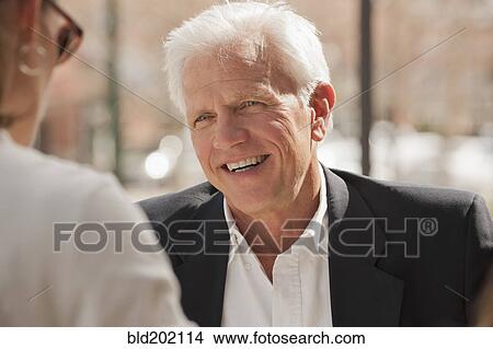 Picture - Caucasian couple talking outdoors. Fotosearch