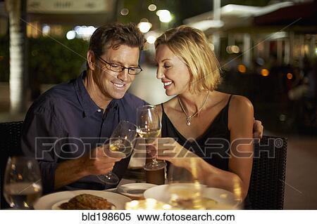Stock Photography - Caucasian couple toasting with wine in restaurant. Fotosearch