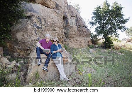 Caucasian couple using digital tablet in remote area View Large Photo Image Stock Image - Caucasian couple using digital tablet in remote area. Fotosearch