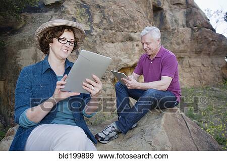 Caucasian couple using digital tablet in remote area View Large Photo Image Stock Photo - Caucasian couple using digital tablet in remote area. Fotosearch