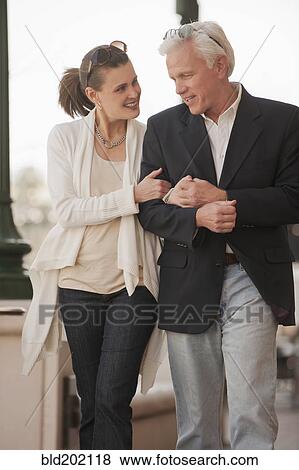 Stock Photo - Caucasian couple walking arm in arm. Fotosearch