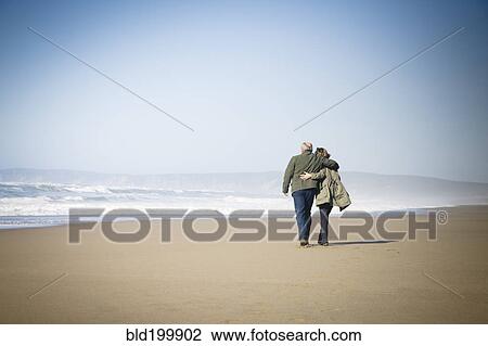 Caucasian couple walking on beach View Large Photo Image Stock Image - Caucasian couple walking on beach. Fotosearch