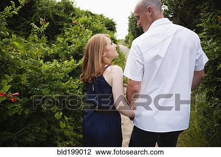 Caucasian couple walking on path outdoors View Large Photo Image Stock Image - Caucasian couple walking on path outdoors. Fotosearch