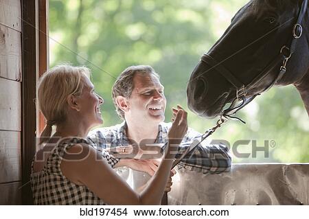 Caucasian couple watching horse View Large Photo Image Picture - Caucasian couple watching horse. Fotosearch