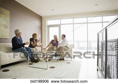 Caucasian couples drinking wine in modern living room View Large Photo Image Stock Photograph - Caucasian couples drinking wine in modern living room. Fotosearch