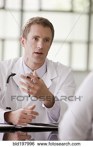 Stock Photograph - Caucasian doctor talking to patient. Fotosearch
