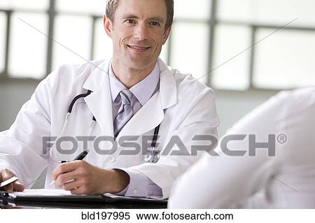 Stock Photography - Caucasian doctor talking to patient. Fotosearch
