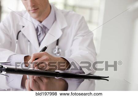 Stock Photo - Caucasian doctor writing in medical record. Fotosearch