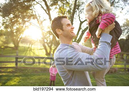 Caucasian father lifting daughter View Large Photo Image Picture - Caucasian father lifting daughter. Fotosearch