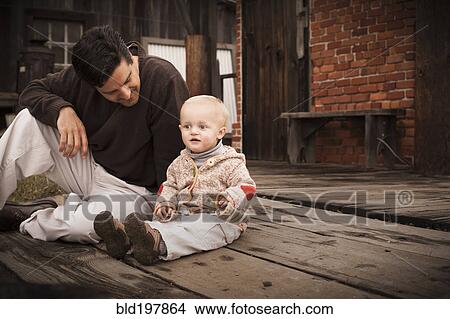Picture - Caucasian father sitting on floor with son. Fotosearch
