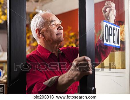 Caucasian florist hanging open sign in shop View Large Photo Image Stock Image - Caucasian florist hanging open sign in shop. Fotosearch