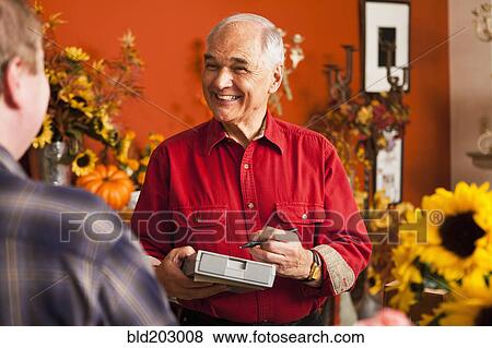 Stock Photo - Caucasian florist taking orders in shop. Fotosearch