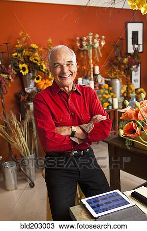 Stock Image - Caucasian florist using tablet computer in shop. Fotosearch