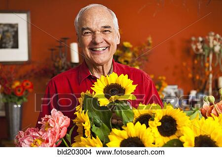 Picture - Caucasian florist with bouquet in shop. Fotosearch