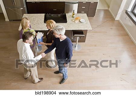 Picture - Caucasian friends talking together in modern kitchen. Fotosearch